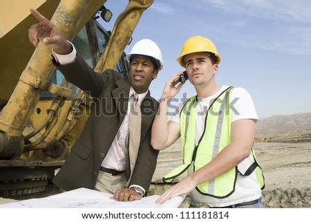 Architect wearing hard hat as he\'s on call at construction site