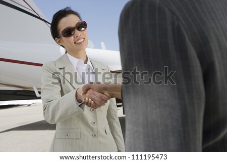 Businesswomen giving each other a handshake at the airport
