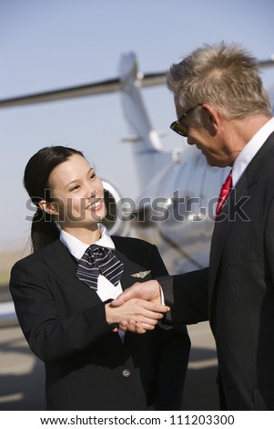 Senior business man thanking pretty Korean stewardess at airfield