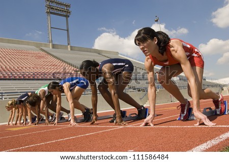 Female athletes at starting line on race track