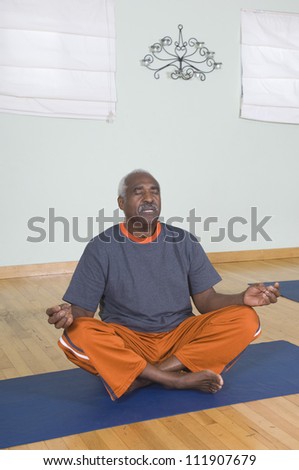 An African American senior man meditating in lotus position