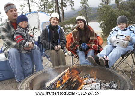 Family in front of campfire ready to toast marshmallow