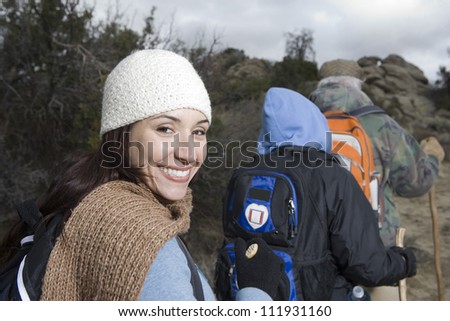 Senior couple and happy daughter with sticks hiking