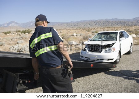 Man towing damaged car away