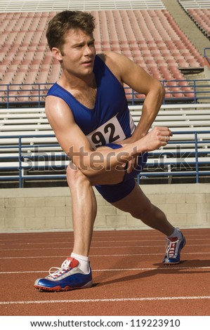 Runner stretching on a track
