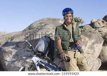 Similar – Foto Bild Mountainbiker aufgestützt auf Fahrradlenker blickt in die Ferne.