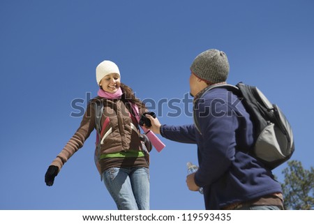 Low angle view Hispanic couple holding hands against blue sky
