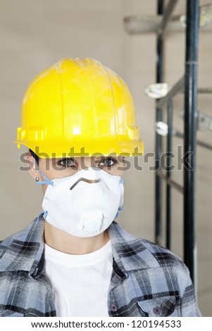 Portrait of woman worker wearing dust mask at construction site