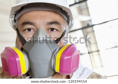 Portrait of male worker wearing dust mask at construction site