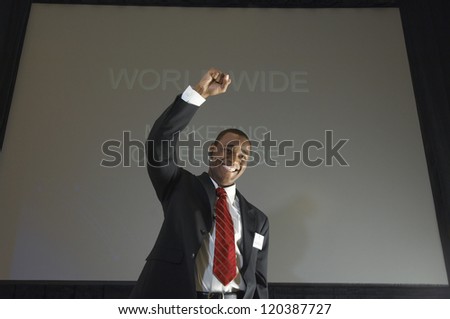 Low angle view of a happy African American businessman celebrating success against projector screen