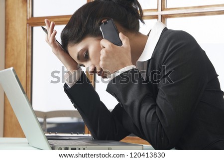 Side view of a tensed business woman communicating on cell phone