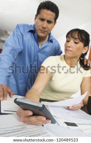 Woman showing calculation to man at home