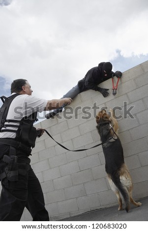 A police man with trained dog catching thief