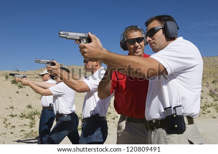 Lieutenant standing with troops holding guns on training