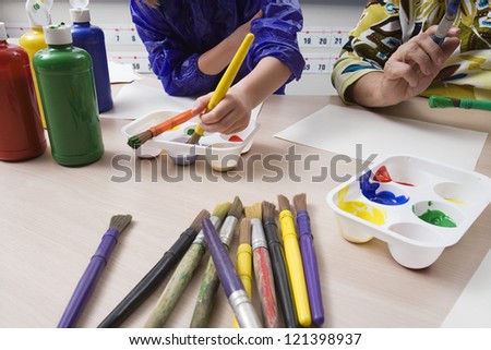 Female student with teacher in art class