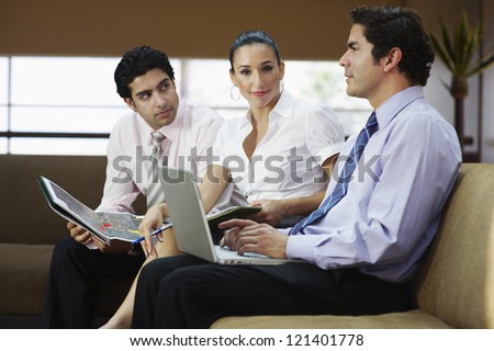 Portrait of a business woman sitting with colleagues on sofa