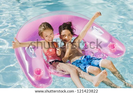Happy preadolescent friends enjoying in swimming pool