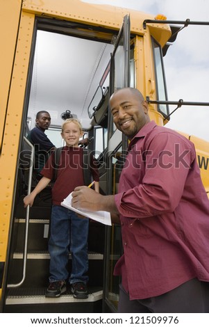 Low angle view of man writing on paper while boy getting down from school bus