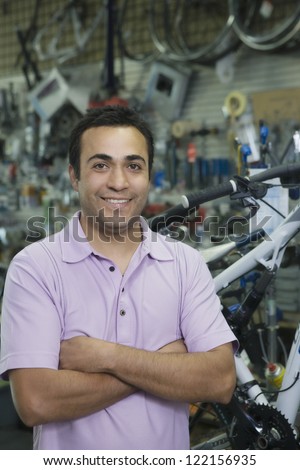 Portrait of a confident shop keeper with arms crossed standing in a shop