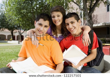 Portrait of three friends with books at college campus