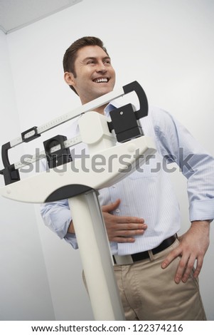 Middle aged man looking at scale of weighing machine