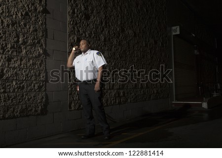 Security guard with torch patrols on duty