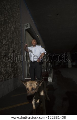 Security guard with dog patrols on duty