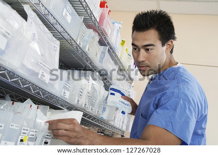 Low Angle View Of A Male Pharmacist In Uniform Keeping Medical Supplies ...