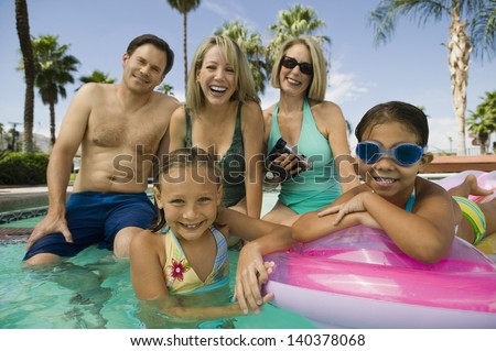 Portrait of smiling two girls with parents and grandmother in the swimming pool