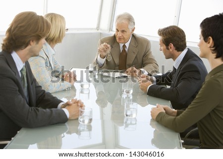 Senior businessman with colleagues having a discussion in conference room