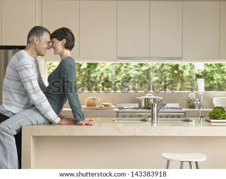 Happy couple rubbing noses at kitchen counter