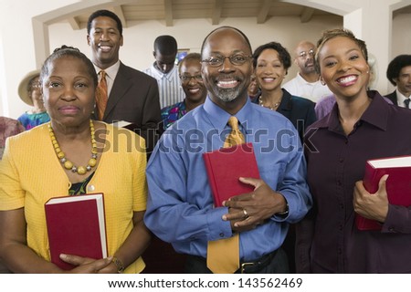 Portrait of smiling African American people standing with bibles in the church