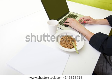 Close up of woman\'s hands typing on laptop with mug in foreground