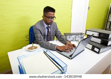 Portrait of Indian Businessman working on his laptop computer at his desk