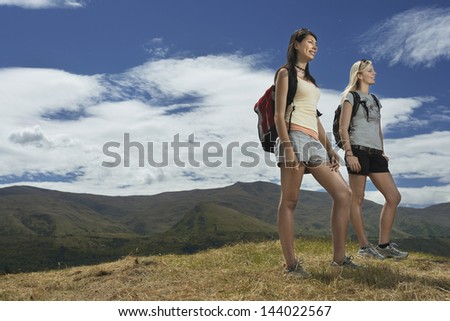 Full length low angle view of two young women hiking in hills