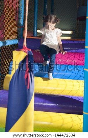 Young girl climbing down play gym