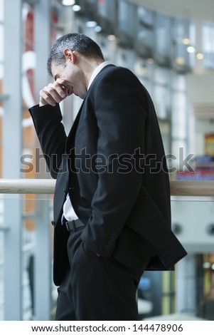 Businessman smirking and covering eyes