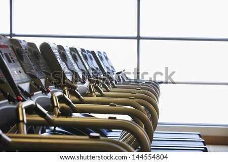 Gym with windows and row of running machines