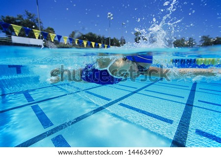 Side view of a young female swimmer in pool
