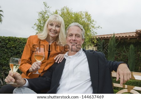 Portrait of a middle aged couple with wine glasses in the garden