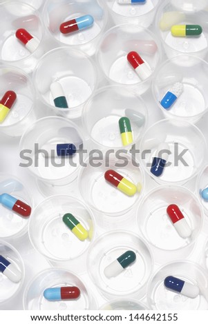 Capsule pills in plastic cups