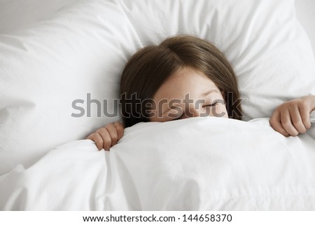 High angle view of little girl sleeping in bed
