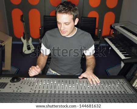 Young male sound technician in recording studio