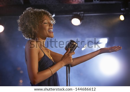 Profile shot of a happy female jazz singer on stage