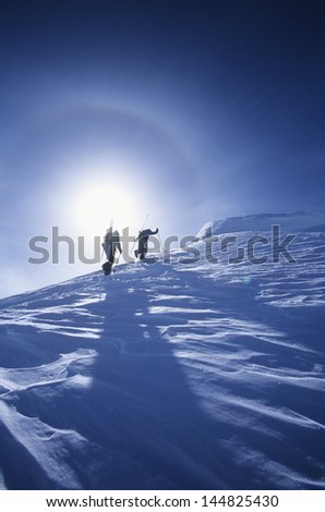Low angle view of skiers hiking to mountain summit