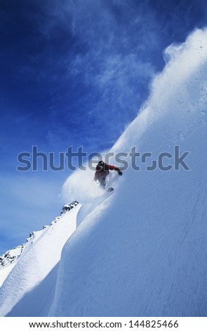 Low angle view of man snowboarding on steep slope