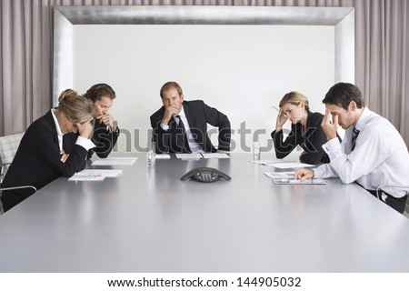 Group of serious business people on conference call in boardroom