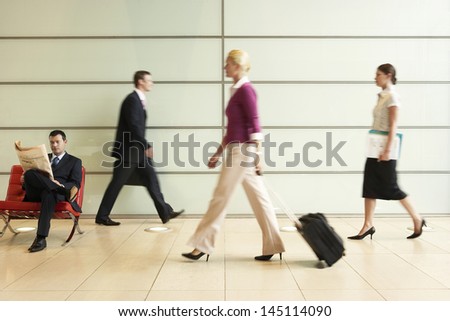 Profile shot of businesspeople walking in office corridor