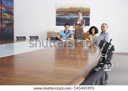Portrait of businesspeople in meeting at the end of a conference table