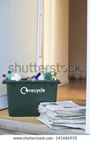 Closeup of recycling container and pile of waste papers on floor